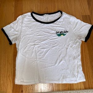 White soft t shirt with black trimming: see you later 🐊
